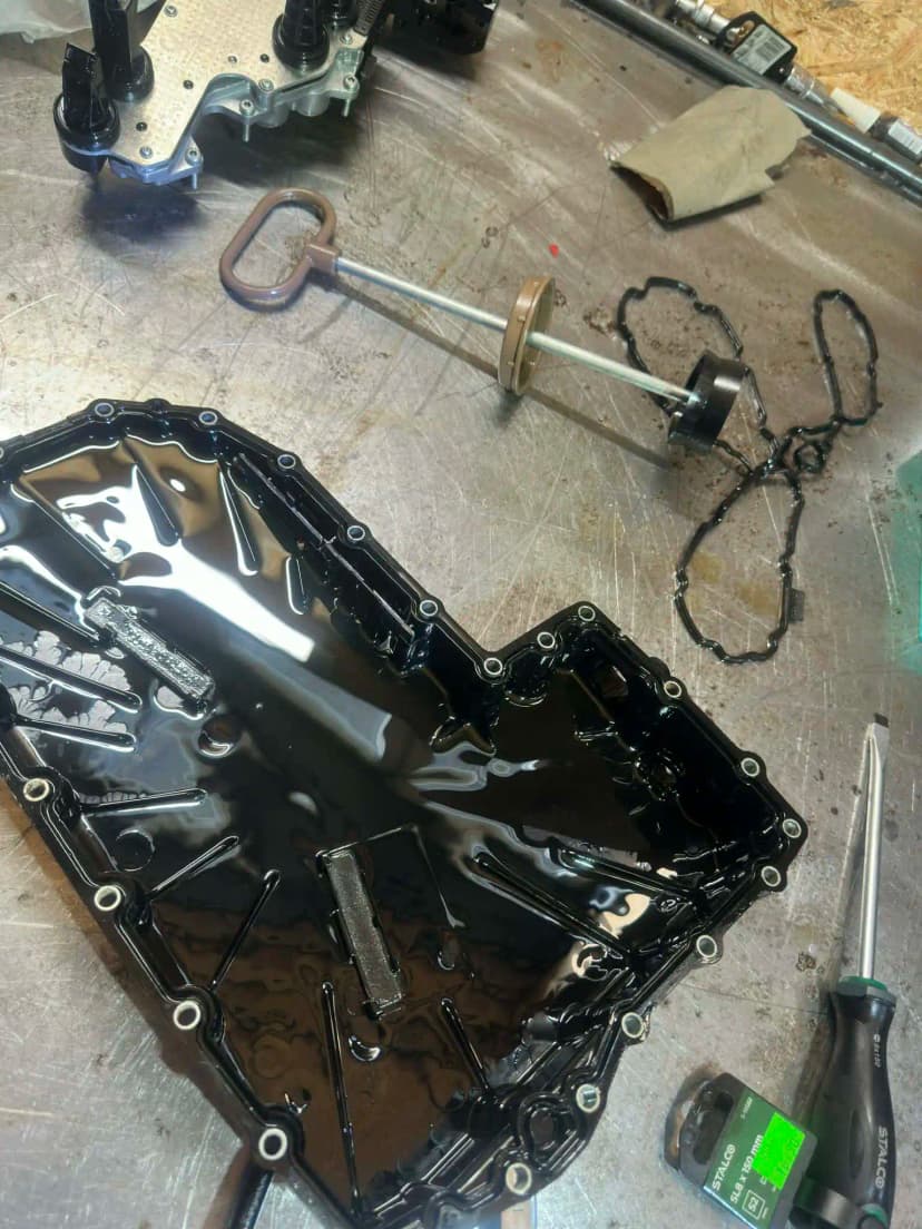 Stara miska olejowa 0CK – widoczne opiłki na magnesach i zużyty filtr