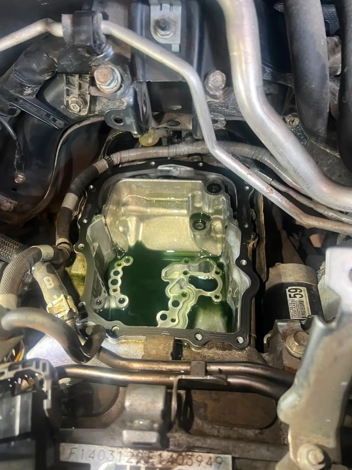 Zdjęta miska olejowa skrzyni CVT Subaru z widocznym płynem CVT w korpusie przekładni